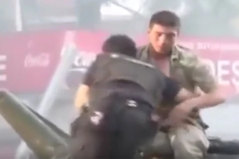 Viên cảnh sát kéo người lính ra khỏi chiếc xe tăng (Nguồn: RT)