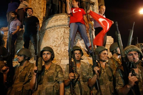 Người biểu tình và binh lính ủng hộ chính quyền giương cao quốc kỳ ở thủ đô Istanbul (Nguồn: BostonGlobe) 