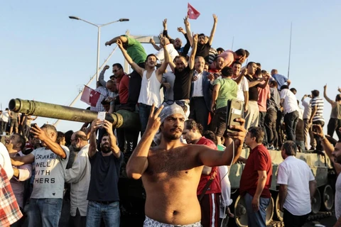 Người ủng hộ chính quyền chụp ảnh tự sướng cạnh một chiếc xe tăng của phe đảo chính (Nguồn: Independent)
