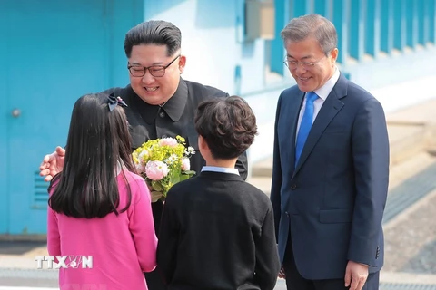 Tổng thống Hàn Quốc Moon Jae-in và Nhà lãnh đạo Triều Tiên Kim Jong-un nhận hoa chúc mừng từ các em thiếu nhi Hàn Quốc tại lễ đón ở quảng trường làng đình chiến Panmunjom ngày 27/4. (Nguồn: YONHAP/TTXVN)