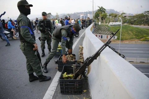 Lính ủng hộ ông Guaido lập các chốt vũ trang quanh căn cứ không quân La Carlota ở Caracas. (Nguồn: Guardian)