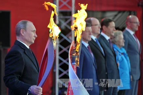 Tổng thống Nga Vladimir Putin và ngọn đuốc Sochi 2014 (Nguồn: AFP/TTXVN)
