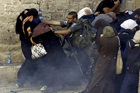 Cảnh sát Israel xô đẩy phụ nữ Palestine trong một vụ đụng độ ở Thành cổ Jerusalem. (Ảnh: AP)