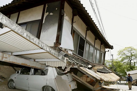 Ngôi nhà đổ sập vào một chiếc ô tô tại thành phố Mashiki sau trận động đất hôm 14/4. (Ảnh: Reuters)