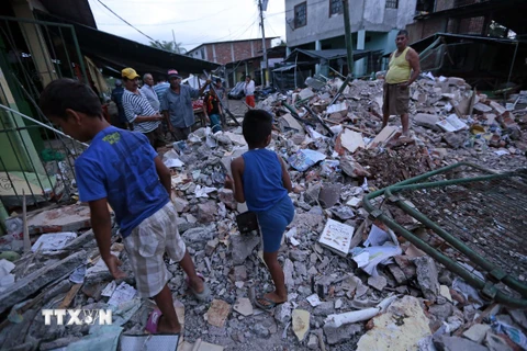 Người dân tìm kiếm đồ đạc sót lại bên những căn nhà bị đổ sập trong động đất tại Manta, Ecuador ngày 17/4. (Ảnh: AFP/TTXVN)