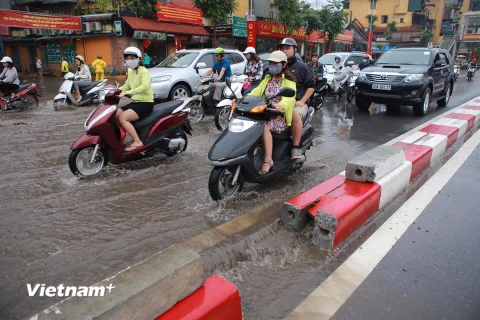 Công ty thoát nước Hà Nội buộc phải dỡ dải phân cách để nước chảy bớt ra hồ Ngọc Khánh. (Ảnh: Minh Sơn/Vietnam+)
