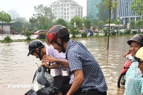 Xe cải tiến chở xe máy thoát khỏi khu vực ngập lụt quanh Keangnam có giá 50.000 đồng/xe. (Ảnh: PV/Vietnam+)