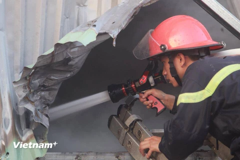 Lực lượng cảnh sát phòng cháy chữa cháy nỗ lực chiến đấu với ngọn lửa. (Ảnh: Minh Sơn/Vietnam+)