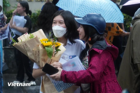 Phụ huynh chờ đón con em với bó hoa tươi thắm. (Ảnh: PV/Vietnam+)