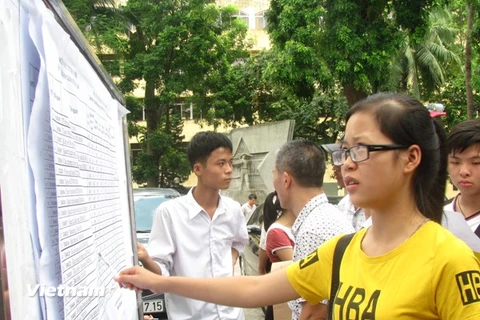 Thí sinh xem điểm trúng tuyển dự kiến tại Đại học Kinh tế quốc dân. (Ảnh: Phạm Mai/Vietnam+)