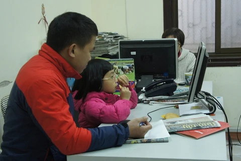 Nghỉ học tránh rét, bé Nguyễn Lam Giang phải lên cơ quan cùng bố. (Ảnh: CTV/Vietnam+)