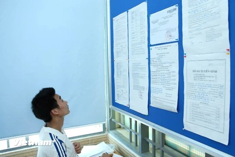 Thí sinh xem thông tin xét tuyển tại Đại học Công nghiệp Hà Nội. (Ảnh: Lê Minh Sơn/Vietnam+)