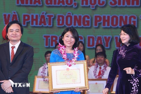 Phó Chủ tịch nước Đặng Thị Ngọc Thịnh và Bộ trưởng Bộ Giáo dục và Đào tạo Phùng Xuân Nhạ trao bằng khen cho các giáo viên, học sinh. (Ảnh: Quý Trung/TTXVN)