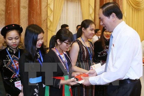 Chủ tịch nước Trần Đại Quang tặng quà cho các em học sinh, sinh viên tiêu biểu tại buổi gặp mặt. (Ảnh: Nhan Sáng/TTXVN)