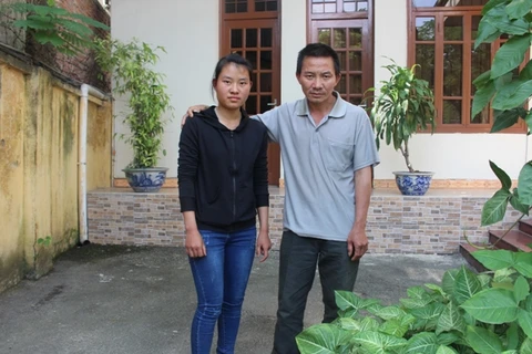 Hai bố con thí sinh Đặng Thị Huyền. (Ảnh: CTV/Vietnam+)