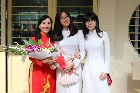Các em học sinh tặng hoa cô hiệu trưởng trường Thực nghiệm Phan Thị Luyến. (Ảnh: CTV/Vietnam+)