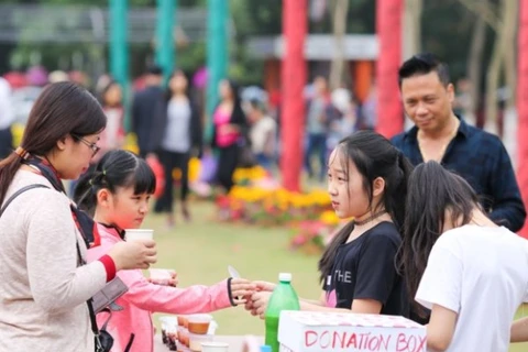 Học sinh tiểu học bán hàng để lấy tiền gây quỹ từ thiện. (Ảnh: Minh Sơn/Vietnam+)