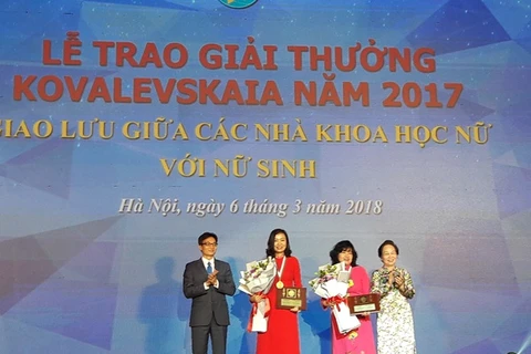 Phó Thủ tướng Vũ Đức Đam và nguyên Phó chủ tịch nước Nguyễn Thị Doan trao giải thưởng cho hai nhà khoa học nữ. (Ảnh: CTV/Vietnam+)