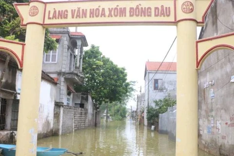 Cả thôn ngập trong nước, người dân phải di chuyển bằng xuồng. (Ảnh: Sơn Bách/Vietnam+)