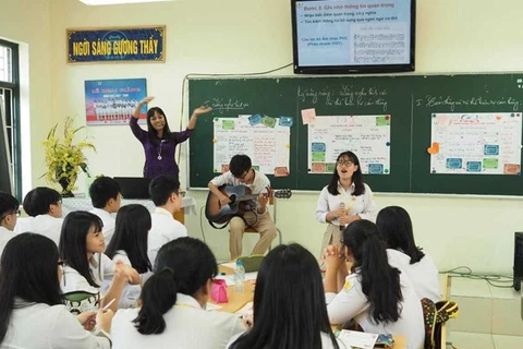 Giờ học theo một cách rất khác của cô Kim Anh, khi học sinh học bằng đàn và hát trên bục giảng. (Ảnh: PV/Vietnam+)