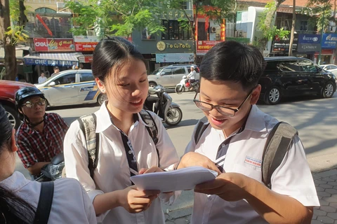 Thí sinh trao đổi bài sau buổi thi môn Ngoại ngữ. (Ảnh: Hồng Kiều/Vietnam+)