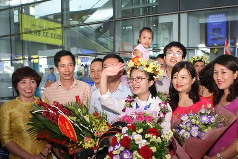 Nguyễn Khánh Linh cười tươi giữa bạn bè, thầy cô và người thân đi đón tại sân bay Nội Bài. (Ảnh: Thanh Tùng) 