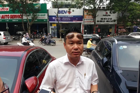 Anh Trương Tất Thành chia sẻ thông tin với báo chí sáng ngày 7/8, tại cổng trường Tiểu học Gateway. (Ảnh: Phạm Mai/Vietnam+)