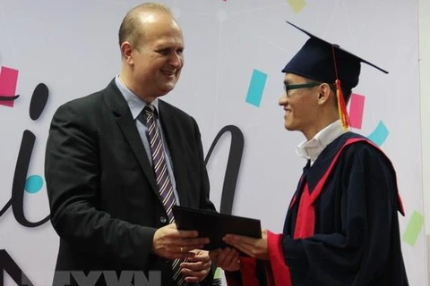 Hiệu trưởng trường Đại học Việt-Đức Jürgen Mallon trao bằng tốt nghiệp cho sinh viên. (Ảnh: Dương Chí Tưởng/TTXVN)