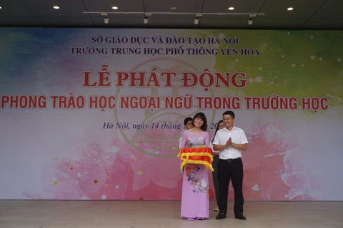 Ông Trần Trọng Hưng, Phó trưởng Ban Đề án Ngoại ngữ quốc gia 2020 tặng sách ngoại ngữ cho Trường Trung học phổ thông Yên Hòa. (Ảnh: PV/Vietnam+)