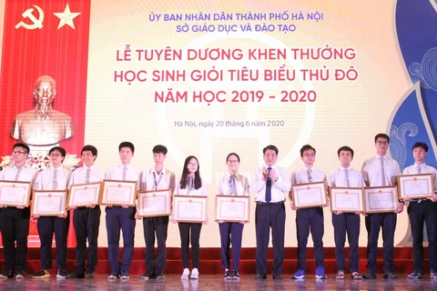 Chủ tịch UBND Thành phố Hà Nội Nguyễn Đức Chung trao tặng Bằng khen cho các học sinh tiêu biểu. (Ảnh: Nguyễn Cúc/TTXVN)