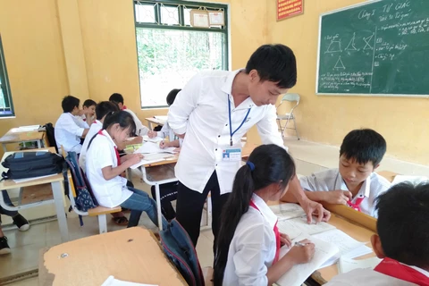 Thầy La Văn Quân tận tình giảng bài trên lớp cho học trò. (Ảnh: PV/Vietnam+)