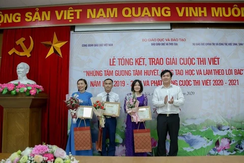 Ban tổ chức trao giải ba cho các tác giả. (Ảnh: PV/Vietnam+)