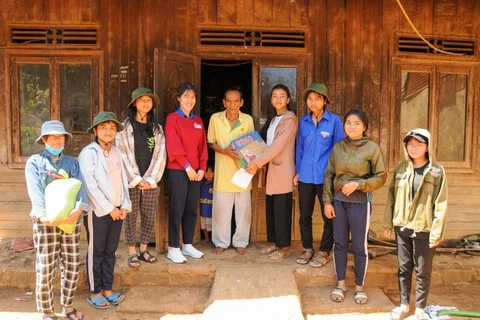 Nhi (mặc áo đỏ) cùng các bạn trong nhóm đến thăm một gia đình có hoàn cảnh khó khăn tại huyện Di Linh. (Ảnh: PV)