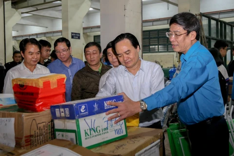 Bộ trưởng Phùng Xuân Nhạ (thứ hai từ phải sang) tham gia hỗ trợ vận chuyển hàng đến học sinh miền Trung. (Ảnh: PV)