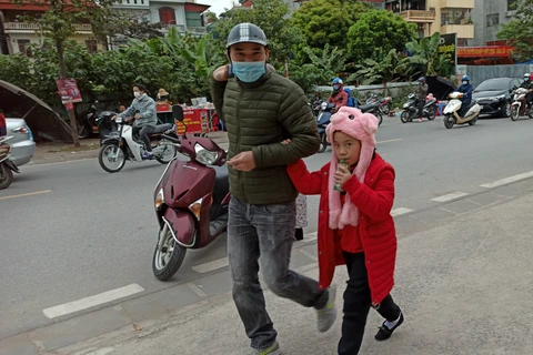 Học sinh Hà Nội đến trường trong giá rét. (Ảnh: PM/Vietnam+)