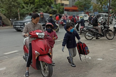 Học sinh Hà Nội đi học trong giá rét. (Ảnh: PM/Vietnam+)