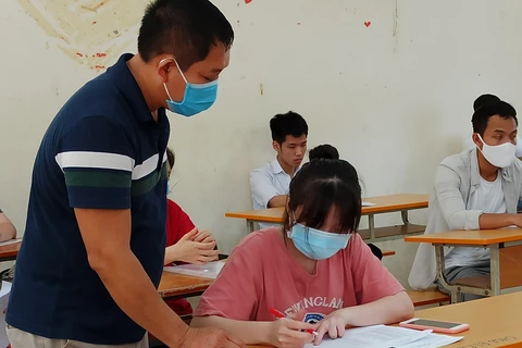 Thí sinh làm thủ tục dự thi Tốt nghiệp Trung học phổ thông. (Ảnh: Phạm Mai/Vietnam+)