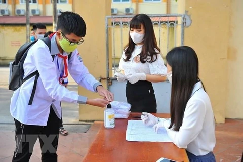 Học sinh thực hiện sát khuẩn tay trước khi vào trường. (Ảnh: TTXVN)