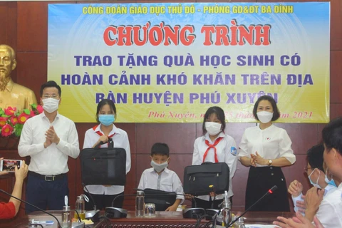 Em Dương Hà Trang (thứ hai từ bên phải sang) và các học sinh có hoàn cảnh khó khăn của huyện Phú Xuyên nhận quà tặng của Phòng Giáo dục và Đào tạo quận Ba Đình. (Ảnh: CTV)
