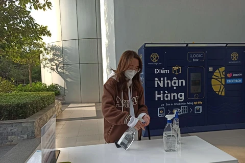 Bình nước sát khuẩn được trang bị ngay lối ra vào tại Đại học Kinh tế quốc dân. (Ảnh: Phạm Mai/Vietnam+)