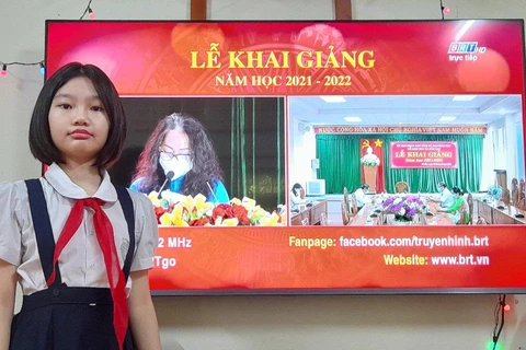 Học sinh bắt đầu năm học mới bằng lễ khải giảng qua màn hình máy tính hoặc trước tivi. (Ảnh: CTV/Vietnam+)