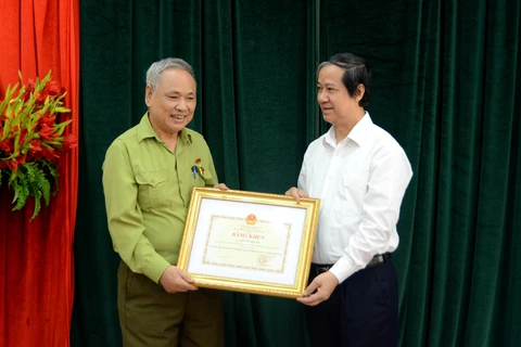 Bộ trưởng Bộ Giáo dục và Đào tạo Nguyễn Kim Sơn tặng bằng khen cho ông Nguyễn Huy Kỳ. (Ảnh: Bộ GD-ĐT)