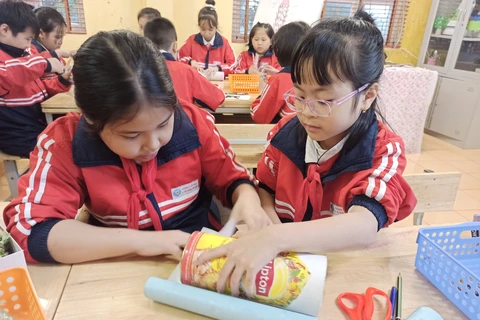Học sinh tham gia chế tạo bình giữ nhiệt từ vật liệu đơn giản quanh em. (Ảnh: PM/Vietnam+)