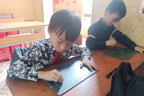 Lý A Mạnh (bên trái), học sinh lớp 4A1, Trường Tiểu học Khao Mang, Mù Cang Chải, Yên Bái trong giờ học tiếng Anh trực tuyến. (Ảnh: PV/Vietnam+)