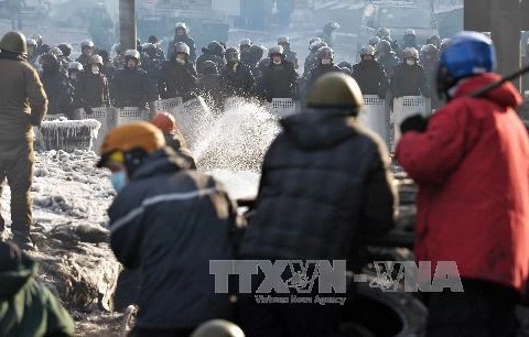 Cảnh sát chống bạo động ngăn dòng người biểu tình chống Chính phủ dựng các rào chắn ở Kiev ngày 27/1. AFP/ TTXVN