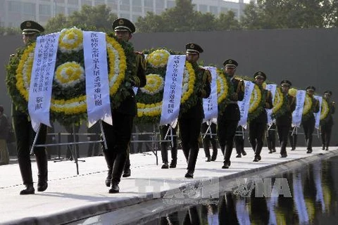 Binh sĩ Trung Quốc đặt hoa tại lễ tưởng niệm các nạn nhân vụ thảm sát Nam Kinh tại Bảo tàng tưởng niệm cuộc thảm sát Nam Kinh. THX-TTXVN