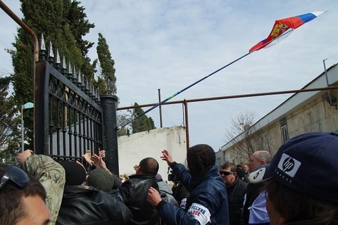 Tự vệ Crimea xô đổ cổng trụ sở Bộ tham mưu Hải quân Ukraine ở Sevastopol (Nguồn: AFP/TTXVN)