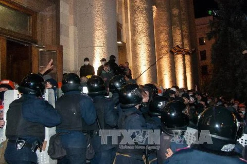 Lực lượng an ninh Ukraine ngăn dòng người biểu tình đột nhập vào tòa nhà chính quyền thành phố Kharkov ngày 6/4. (Ảnh: AFP/TTXVN)