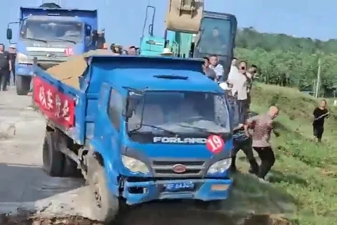 Dân làng Trung Quốc lao cả xe tải chở cát xuống nước để ngăn vỡ đê hồ Động Đình