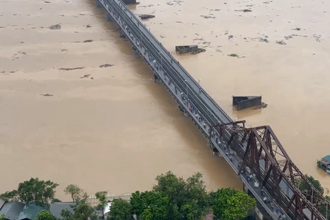 Nước sông Hồng dâng cao và chảy siết nên ngành đường sắt quyết định dừng chạy tàu qua cầu Long Biên. (Ảnh: Vietnam+)